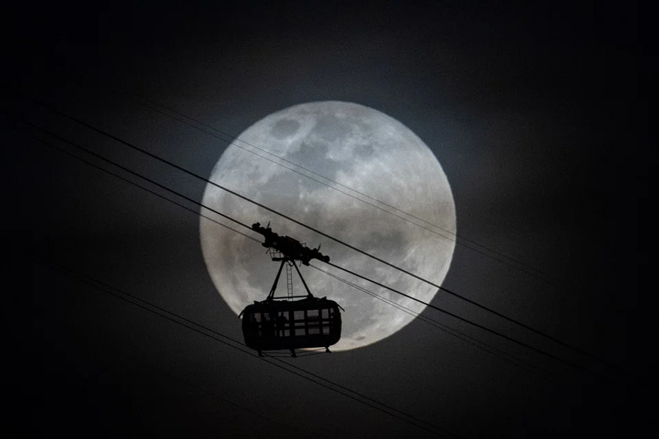 The second supermoon of 2023, also known as the Sturgeon Moon, rises behind the cable car of the Sugarloaf Mountain in Rio de Janeiro, Brazil, on 1 August 2023. (Mauro Pimentel/AFP)