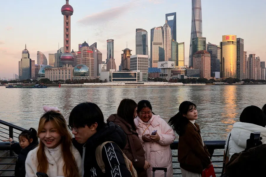 People hang out at The Bund as the financial district of Pudong is seen in the background in Shanghai, China, on 16 January 2025. (Go Nakamura/Reuters)