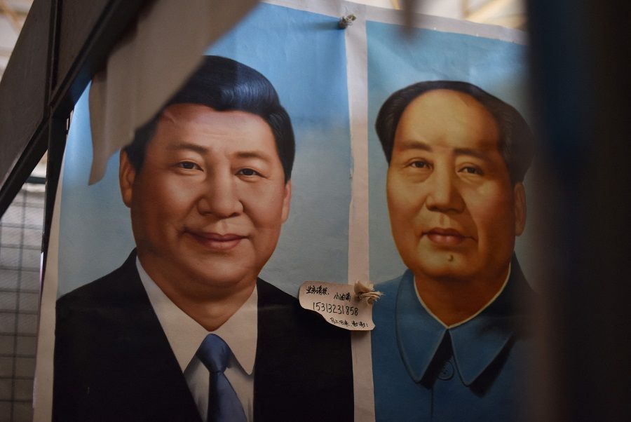 In this file photo taken on 20 September 2017, painted portraits of Chinese President Xi Jinping (left) and late communist leader Mao Zedong are seen at a market in Beijing, China. (Greg Baker/AFP)