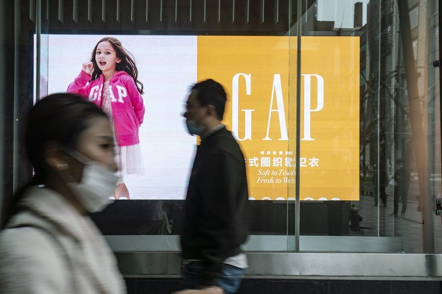 Pedestrians going past shop windows in China on 9 March 2021. (Qilai Shen/Bloomberg)