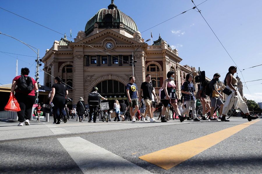 People cross a street in Melbourne on 12 February 2021. (Con Chronis/AFP)