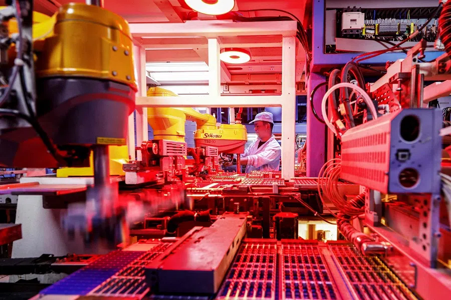 An employee works on solar photovoltaic modules for export at a factory in Sihong, Jiangsu province, China, on 3 September 2024. (STR/AFP)