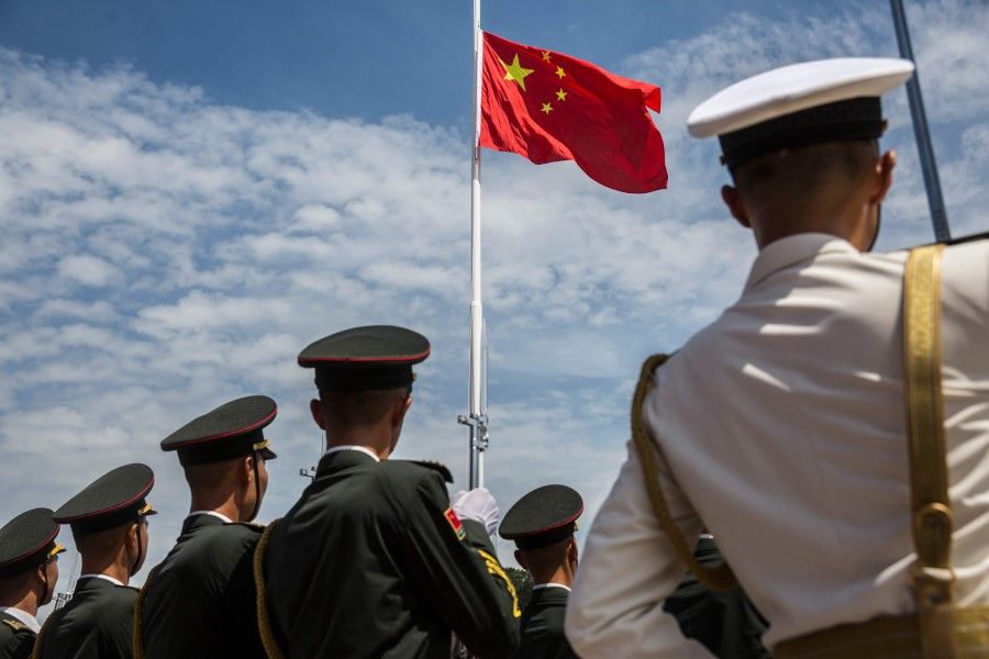 This file photo shows soldiers from the Peoples' Liberation Army (PLA) during a flag raising ceremony, 30 June 2019. (Isaac Lawrence/AFP)