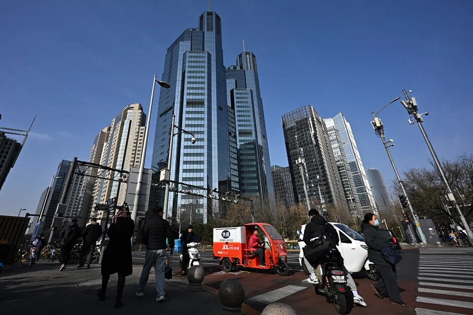 Pedestrians crossing the road in front of office and commercial buildings in the central business district of China's capital Beijing, on 9 December 2023. (SPH Media)