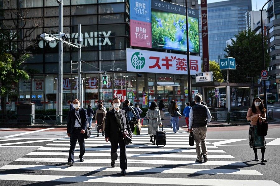People walk on a pedestrian crossing in Tokyo on 16 November 2020. (Charly Triballeau/AFP)