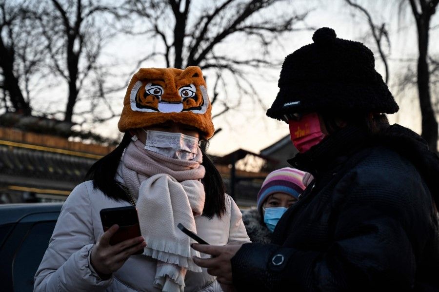 A woman wears a festive tiger hat on the second day of the Lunar New Year of the Tiger in Beijing on 2 February 2022. (Jade Gao/AFP)