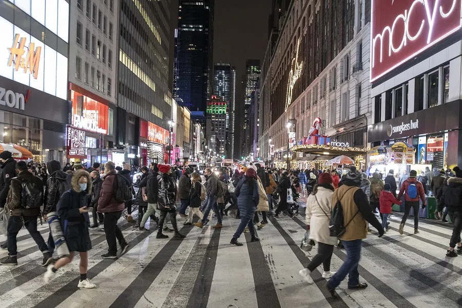 Shoppers cross 34th Street in New York, US, on 27 December 2021.