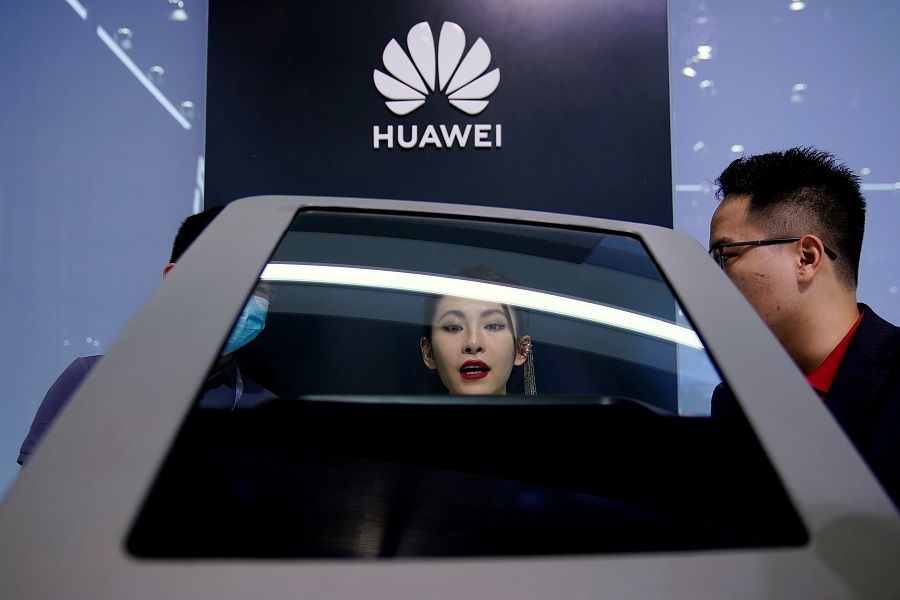 People check a display near a Huawei logo during a media day for the Auto Shanghai show in Shanghai, China, 19 April 2021. (Aly Song/Reuters)