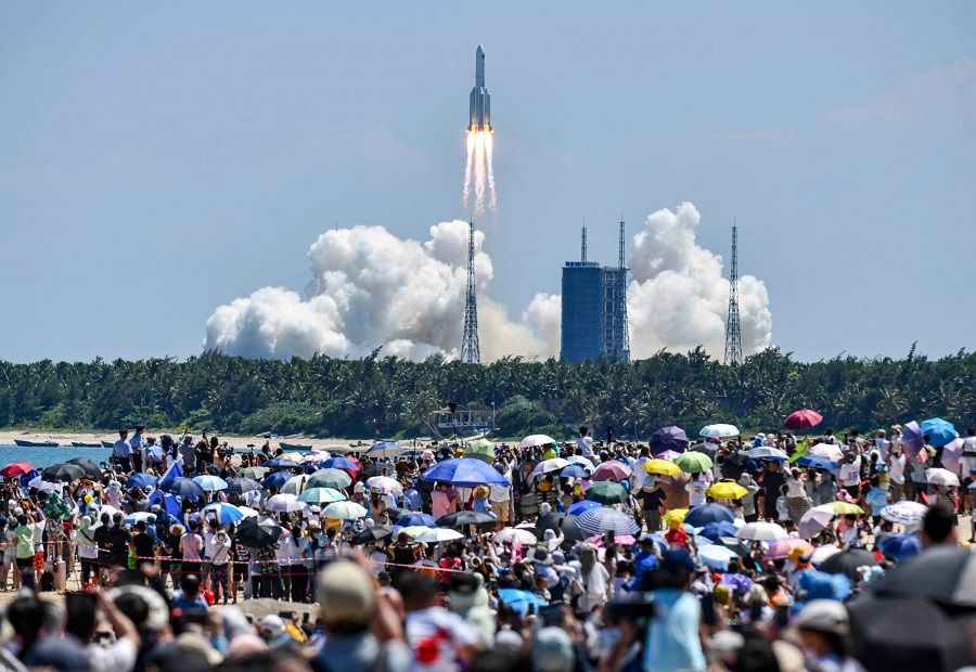 Onlookers watch the launch of a rocket transporting China's second module for its Tiangong space station from the Wenchang spaceport in southern China on 24 July 2022. (CNS/AFP)