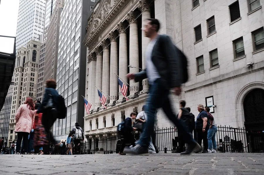 People walk by the New York Stock Exchange on 5 May 2022 in New York City, US. (Spencer Platt/Getty Images/AFP)