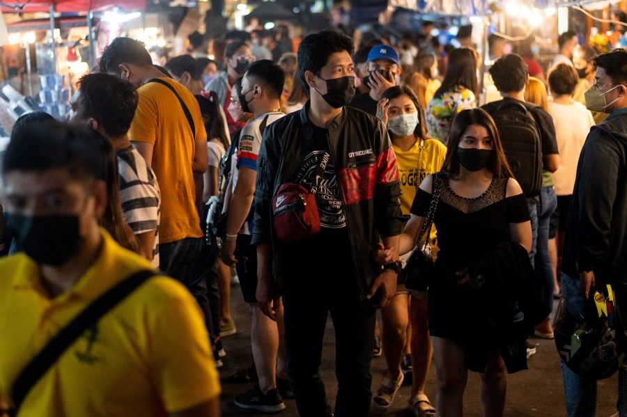 People wearing face masks as protection against the coronavirus disease (Covid-19) visit street food stalls as the country's capital region eases coronavirus restrictions, in Manila, Philippines, 1 March 2022. (Lisa Marie David/Reuters)