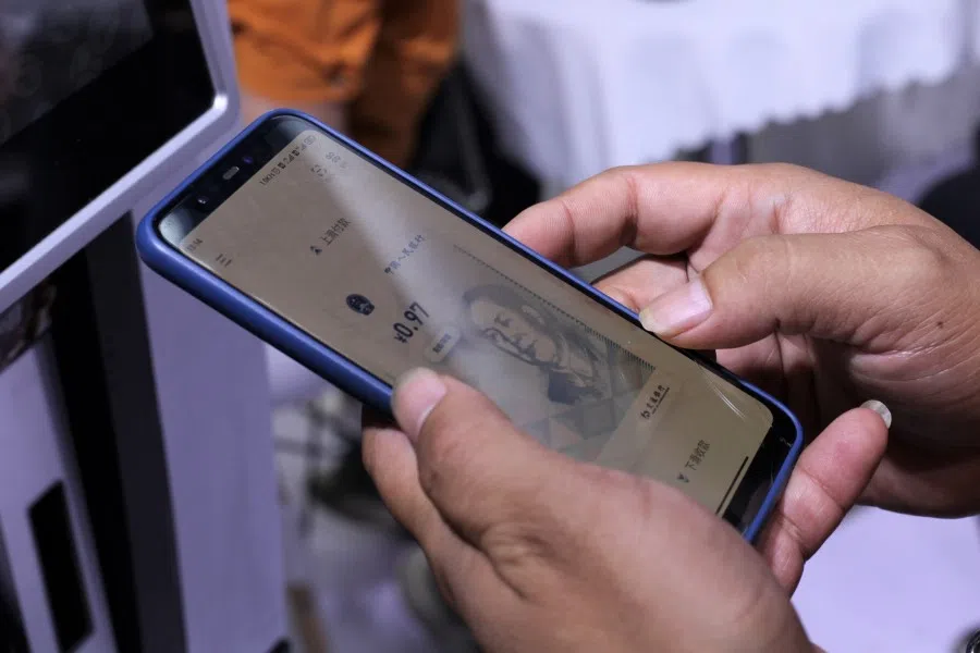 Visitors use digital yuan on their smartphones to buy discounted coffees at a Bank of Communications Co. booth at the China International Fair for Trade in Services (CIFTIS) in Beijing, China, on 7 September 2021. (Bloomberg)