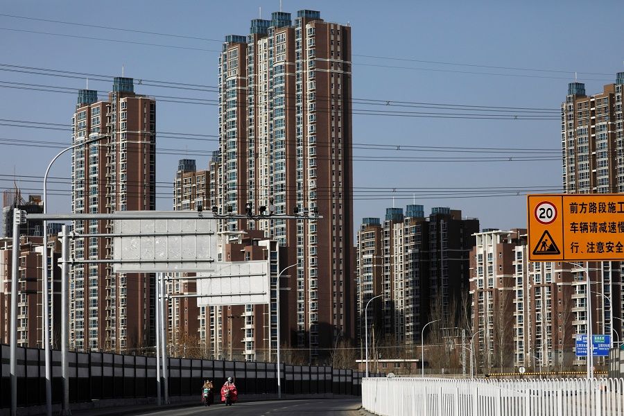 People ride scooters past residential buildings in Beijing, China, 13 January 2021. (Tingshu Wang/File Photo/Reuters)