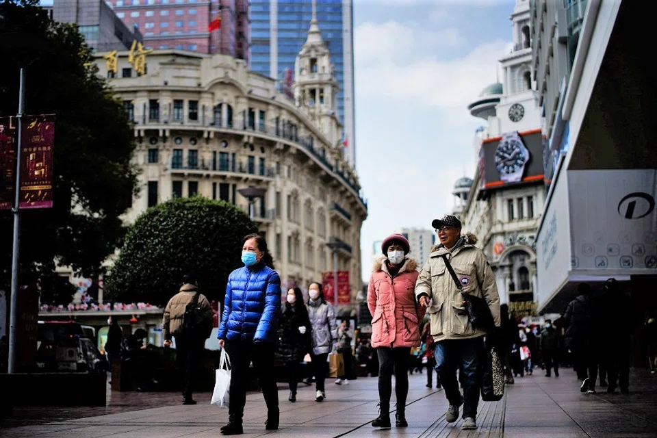 People wearing protective masks visit a main shopping area in Shanghai, China, 21 January 2022. (Aly Song/Reuters)