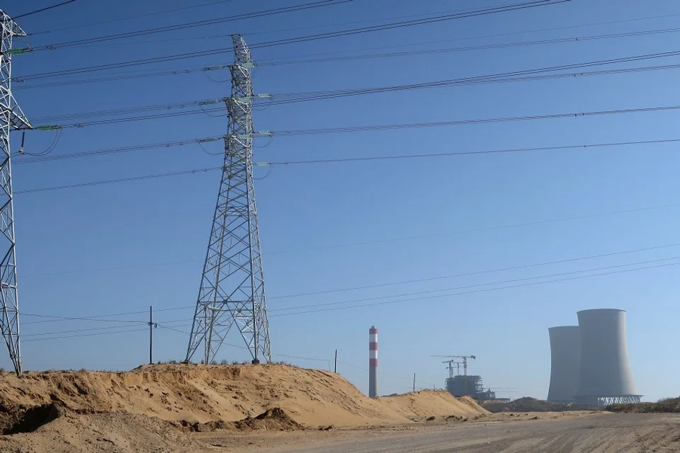 Transmission lines pass in front of the construction site of Shenmu Shenxin power station, a coal-fired power plant, in Shenmu, Shaanxi province, China, on 20 November 2023. (Colleen Howe/Reuters)