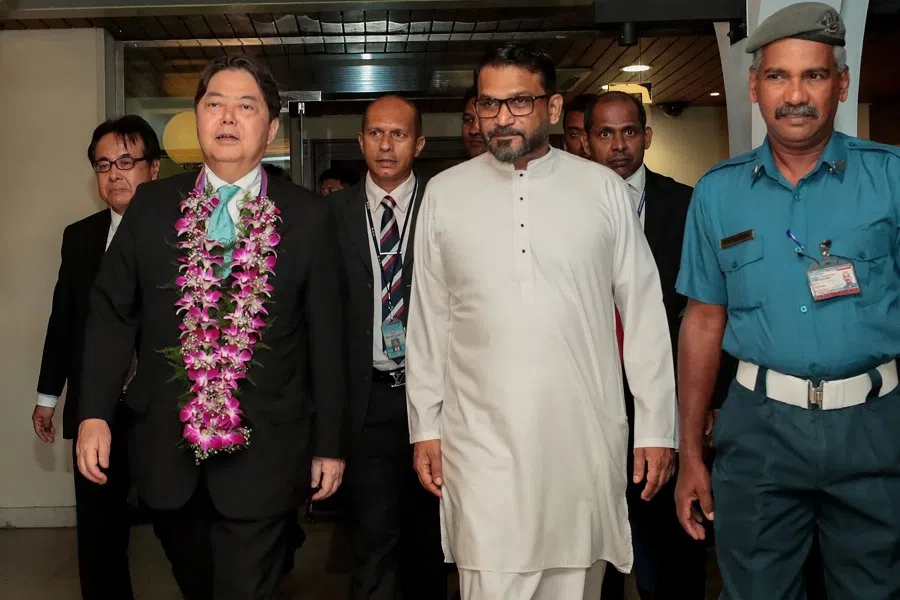 This handout photograph taken on 28 July 2023 and released by Sri Lankan President's Office shows Japan's Foreign Minister Yoshimasa Hayashi walking alongside Sri Lanka's Minister of State for Foreign Affairs Tharaka Balasuriya, upon his arrival in Colombo. (Sri Lankan President's Office/AFP)