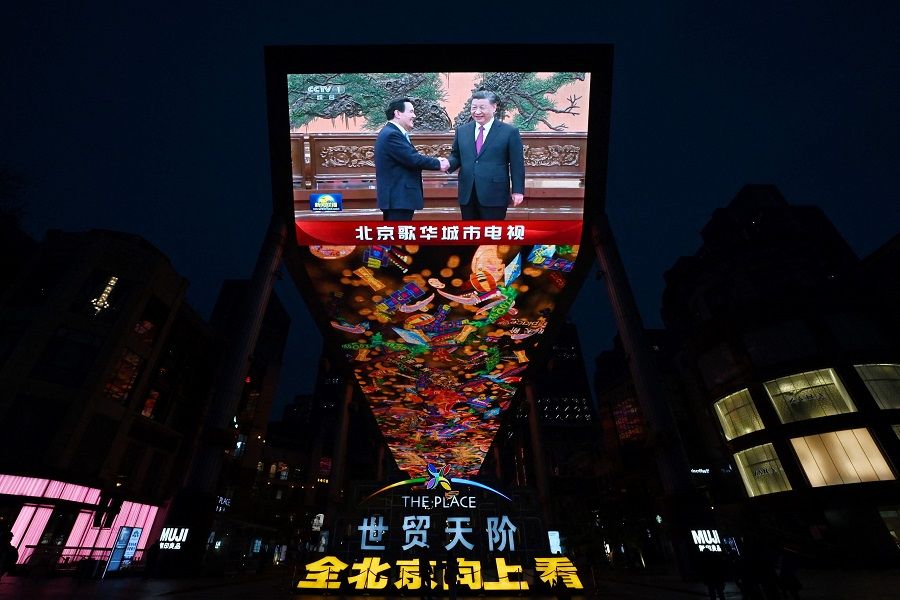 A large screen shows news coverage of Chinese President Xi Jinping (right) meeting former Taiwan President Ma Ying-jeou in Beijing, China, on 10 April 2024. (Greg Baker/AFP)