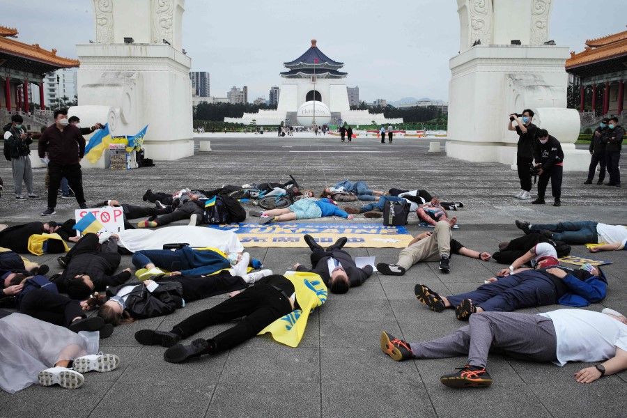 Eastern European nationals living in Taiwan stage a die-in during a demonstration at Free Square in front of the Chiang Kai-shek Memorial Hall in Taipei on 17 April 2022, against the ongoing Russian invasion of Ukraine. (Sam Yeh/AFP)