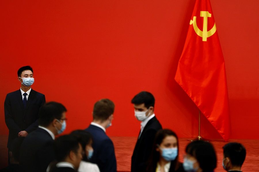 A security personnel keeps watch next to a Chinese Communist Party flag before the new Politburo Standing Committee members meet the media following the 20th Party Congress of the Communist Party of China, at the Great Hall of the People in Beijing, China, 23 October 2022. (Tingshu Wang/Reuters)