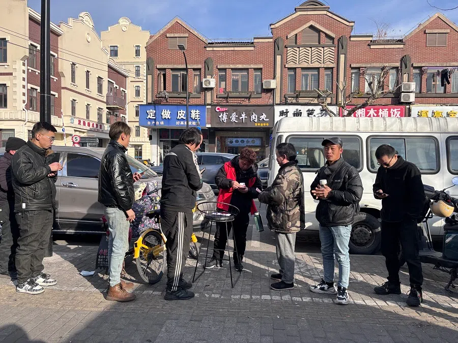 A supervisor gives out salaries to gig workers outside a labour agency in Shanghai.
