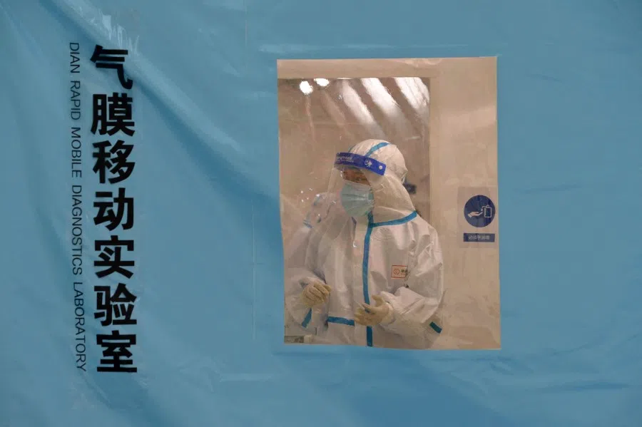 A staff member wearing personal protective equipment (PPE) works at a temporary Covid-19 testing facility in north China's Tianjin on 11 January 2022, after authorities ordered the testing of all 14 million residents. (Photo by AFP)