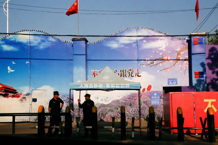 Security guards stand at the gates of what is officially known as a vocational skills education centre in Huocheng County in Xinjiang Uyghur Autonomous Region, China, 3 September 2018. (Thomas Peter/File Photo/Reuters)