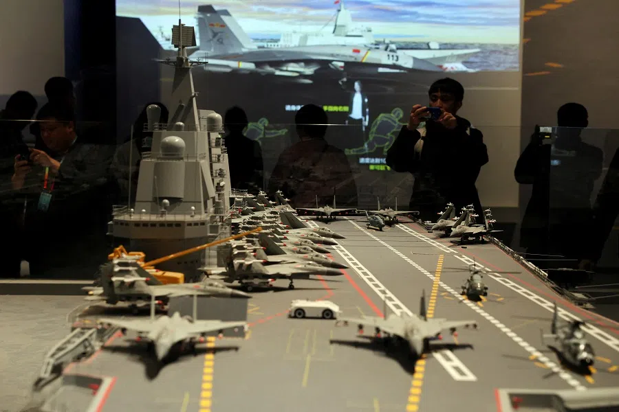 Visitors look at a replica of Liaoning aircraft carrier displayed at the PLA Naval Museum, on the 75th founding anniversary of the Chinese People’s Liberation Army (PLA) Navy, in Qingdao, Shandong province, China, on 23 April 2024. (Florence Lo/Reuters)