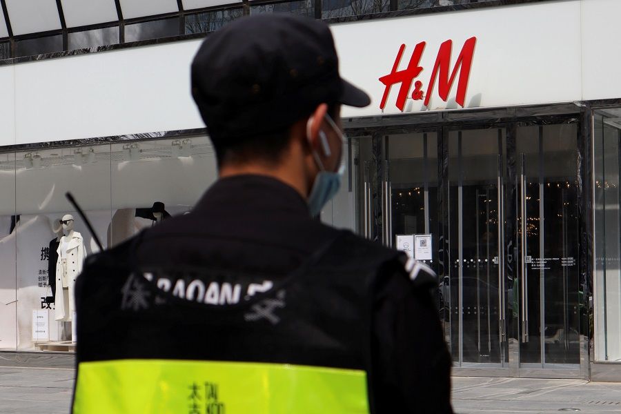 A security guard stands outside a store of Swedish fashion retailer H&M at a shopping complex in Beijing, China, 25 March 2021. (Florence Lo/Reuters)