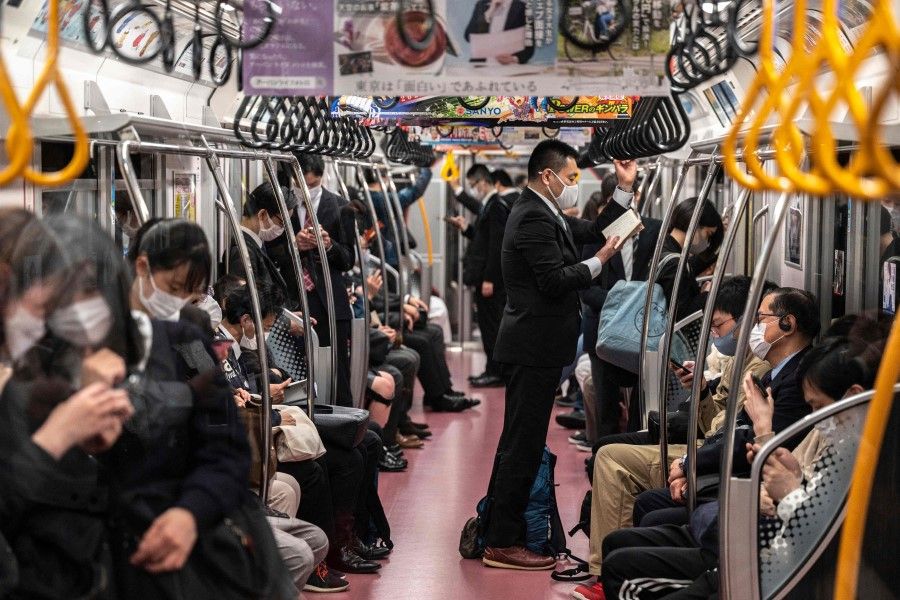 People commute on a train in Tokyo on 23 April 2021. (Charly Triballeau/AFP)