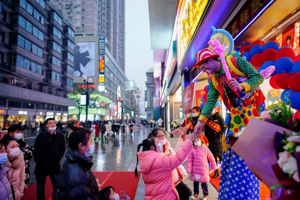 A clown interacts with people at a main shopping area in Wuhan, Hubei province, China, 6 December 2020. (Aly Song/REUTERS)