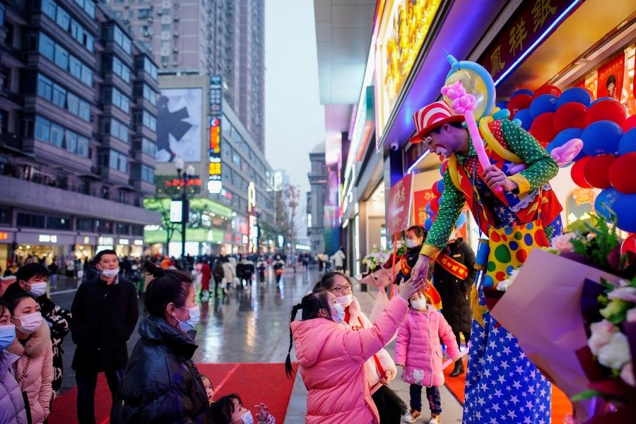 A clown interacts with people at a main shopping area in Wuhan, Hubei province, China, 6 December 2020. (Aly Song/REUTERS)
