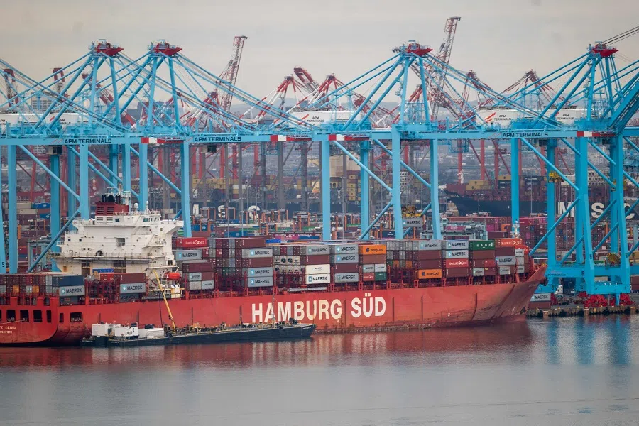 Cranes stand over a cargo ship at the Port of Newark on 26 March 2024 as seen from Bayonne, New Jersey, US. (Spencer Platt/Getty Images/AFP)