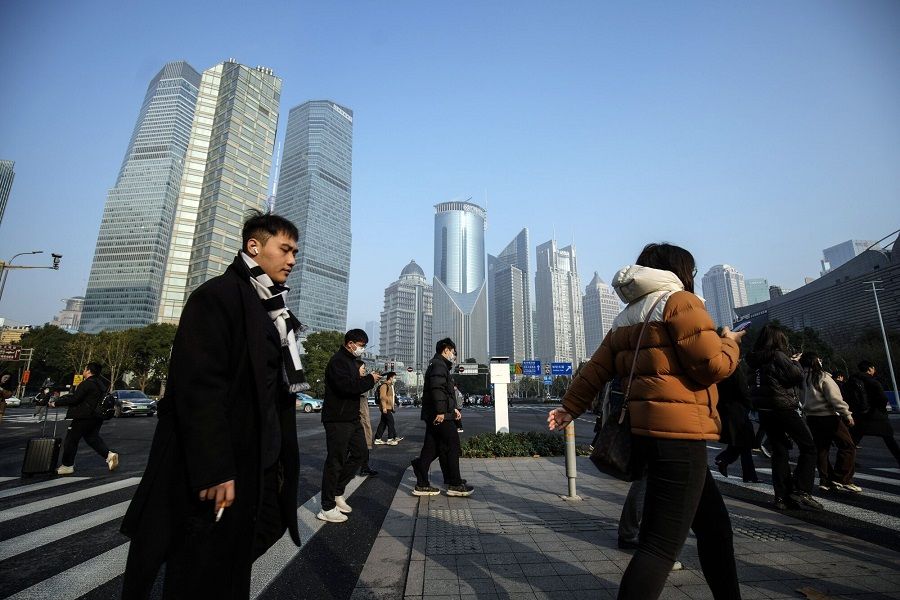 Pedestrians cross a road in Pudong's Lujiazui Financial District in Shanghai, China, on 9 January 2024. (Qilai Shen/Bloomberg)