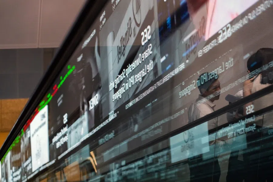 People riding an escalator reflected at the Singapore Exchange Ltd. (SGX) headquarters in Singapore, on 7 February 2023. (Nicky Loh/Bloomberg)