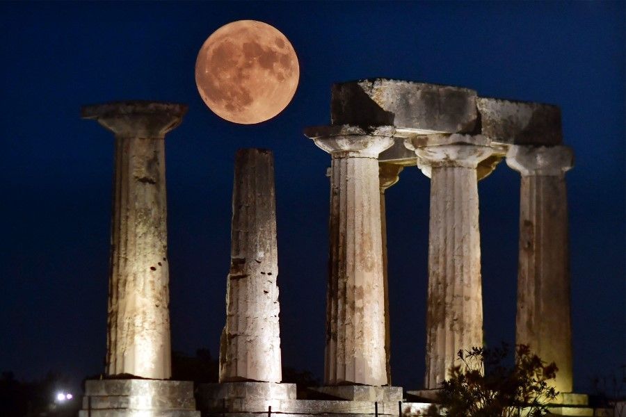 The "Blue Supermoon", the second full moon of a calendar month, rises above the Apollo Temple in ancient Corinth, on 30 August 2023. (Valerie Gache/AFP)