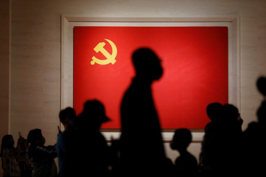 Visitors are seen silhouetted against a Chinese Communist Party flag displayed at the Museum of the Communist Party of China in Beijing, China, 3 September 2022. (Florence Lo/Reuters)
