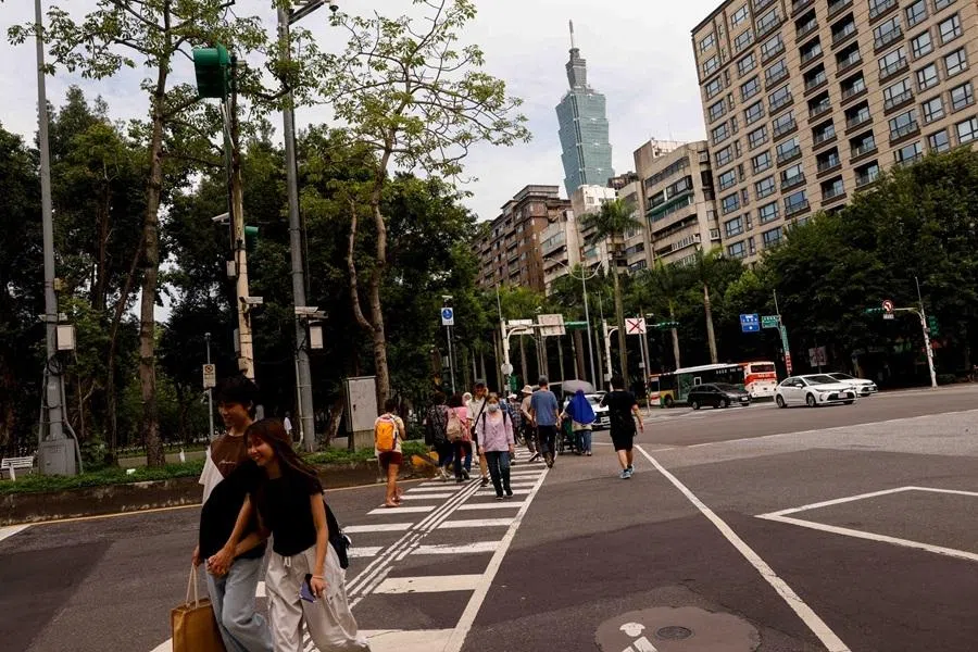 People walk across a street in Taipei, Taiwan, on 12 May 2026.