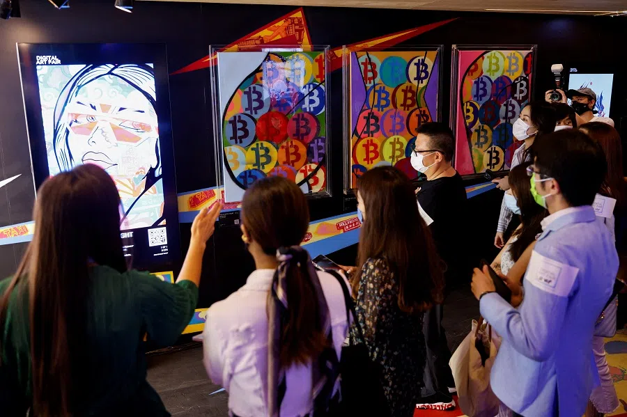 Visitors walk in front of "HOLD ONTO YOUR BITCOIN" by Gustav Szabo, known as Szabotage, which will be converted into NFT and auctioned online at Sotheby's, at the Digital Art Fair, in Hong Kong, China, 30 September 2021. (Tyrone Siu/File Photo/Reuters)