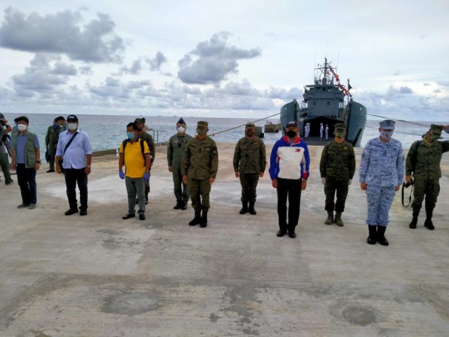 A handout photo provided by Philippines' Department of National Defense shows military and defense officials standing during a ceremony of a newly constructed beach ramp at Thitu Island in the disputed South China Sea, 9 June 2020. (Philippines' Department of National Defense/Handout via REUTERS)