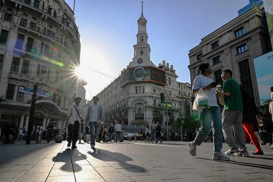 People walk on a pedestrian street in the Huangpu district, in Shanghai, China, on 30 March 2024. (Hector Retamal/AFP)