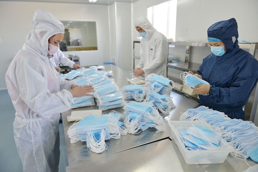 This photo taken on 18 February 2020 shows workers making face masks to satisfy increased demand during China's Covid-19 coronavirus outbreak, at a factory in Nanjing, in China's Jiangsu province. (STR/AFP)