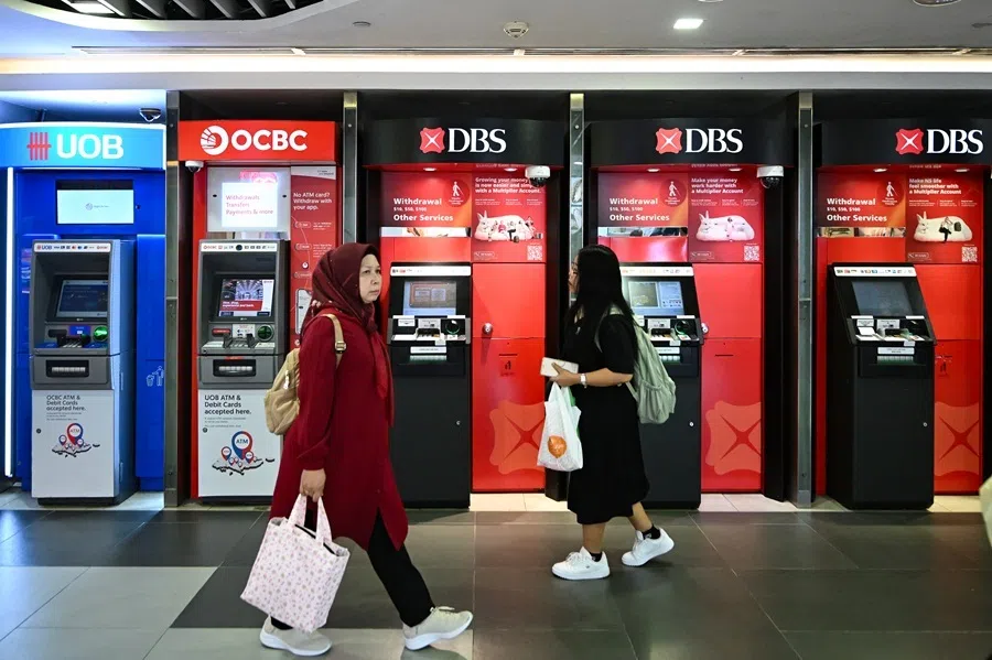 People walk past UOB, OCBC and DBS ATMs at Bugis Junction, Singapore, on 16 September 2025.