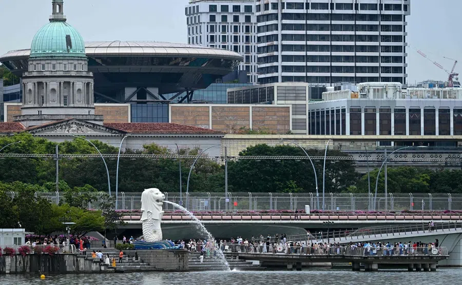 People gather next to the Merlion statue at Marina Bay in Singapore on 26 September 2024. (Roslan Rahman/AFP)
