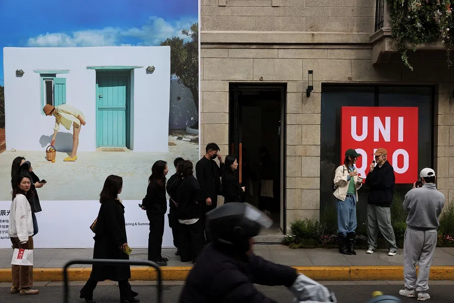 People walk in front of a Uniqlo store in Shanghai, China, 28 February 2025. (Go Nakamura/Reuters)