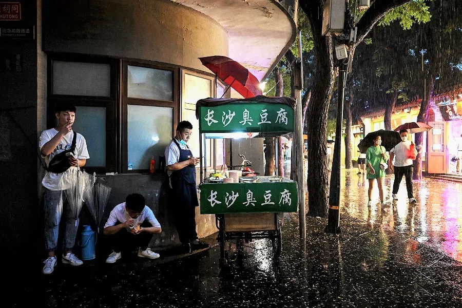 A street vendor (centre) waits for customers in Nanlouguxiang in Beijing, China, on 27 July 2022. (Noel Celis/AFP)