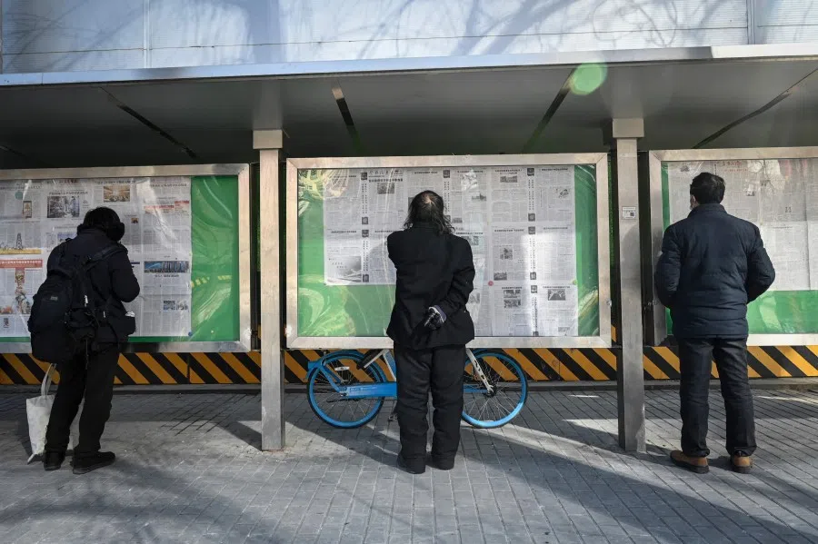 People read the Chinese state-run newspaper with coverage of the conflict between Russia and Ukraine, on a street in Beijing, China, on 24 February 2022. (Jade Gao/AFP)