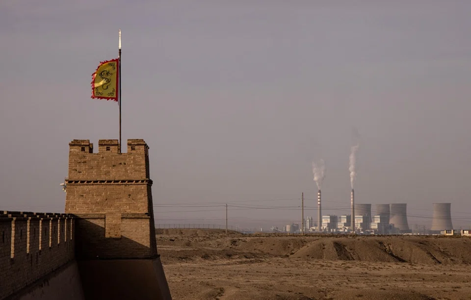 A flag flies atop a watchtower at Jiayu Pass, a strategic point along the Great Wall and the ancient Silk Road, with a power plant visible in the background, in Jiayuguan, Gansu province, China, 29 October 2025. (Maxim Shemetov/Reuters)