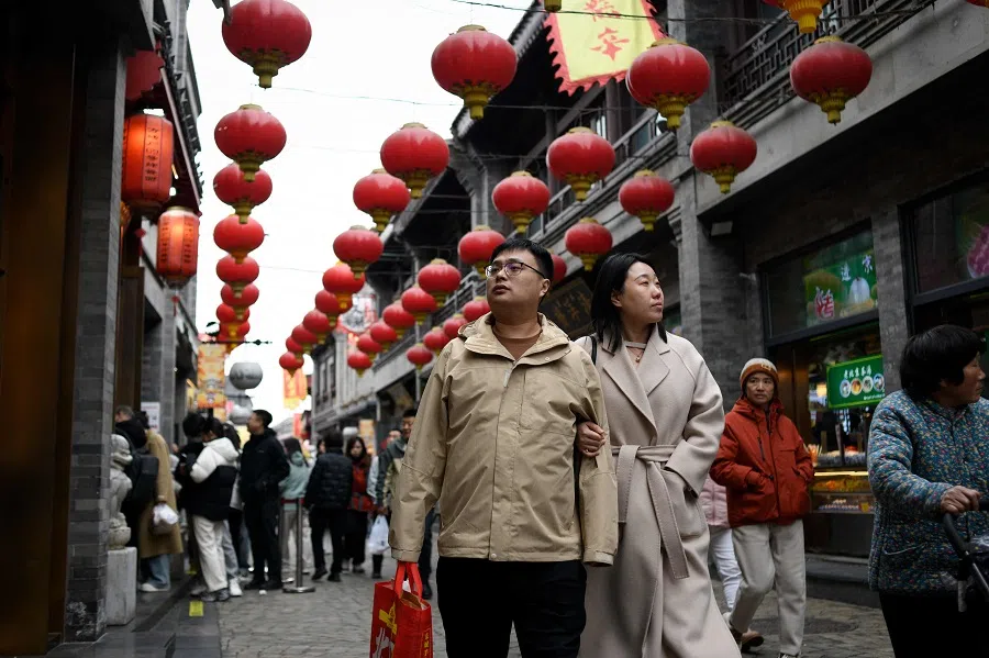 A couple visit a shopping street in Beijing on 2 March 2025. (Wang Zhao/AFP)