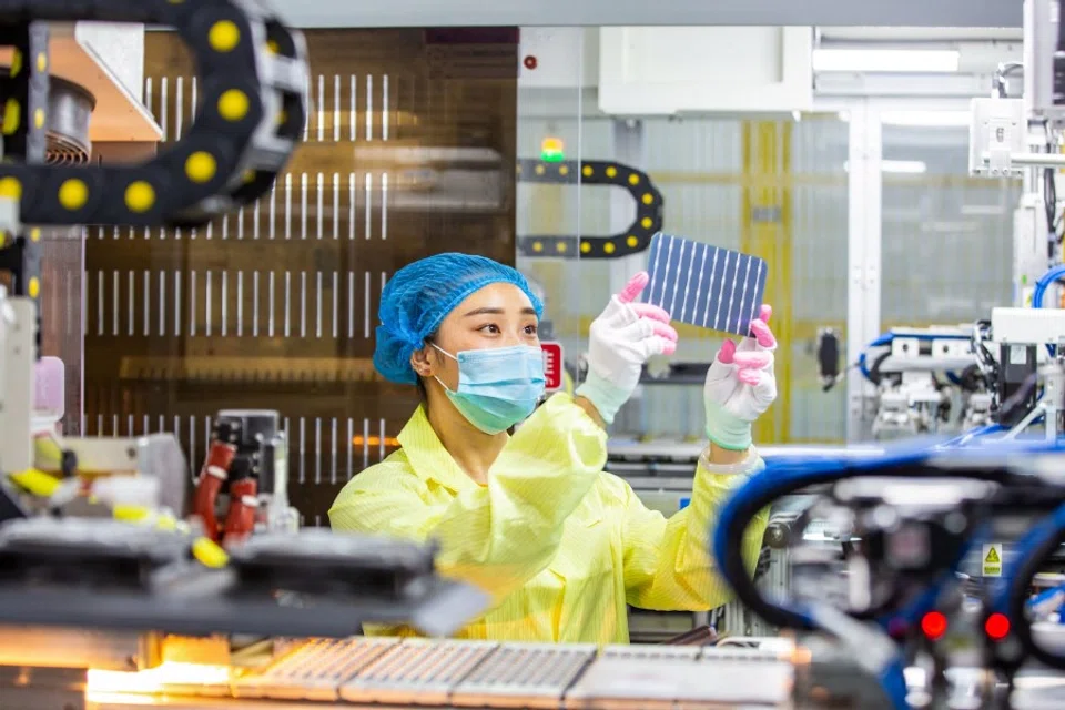 An employee works on solar photovoltaic modules at a factory in Hai'an in China's eastern Jiangsu province on 15 November 2021. (AFP)