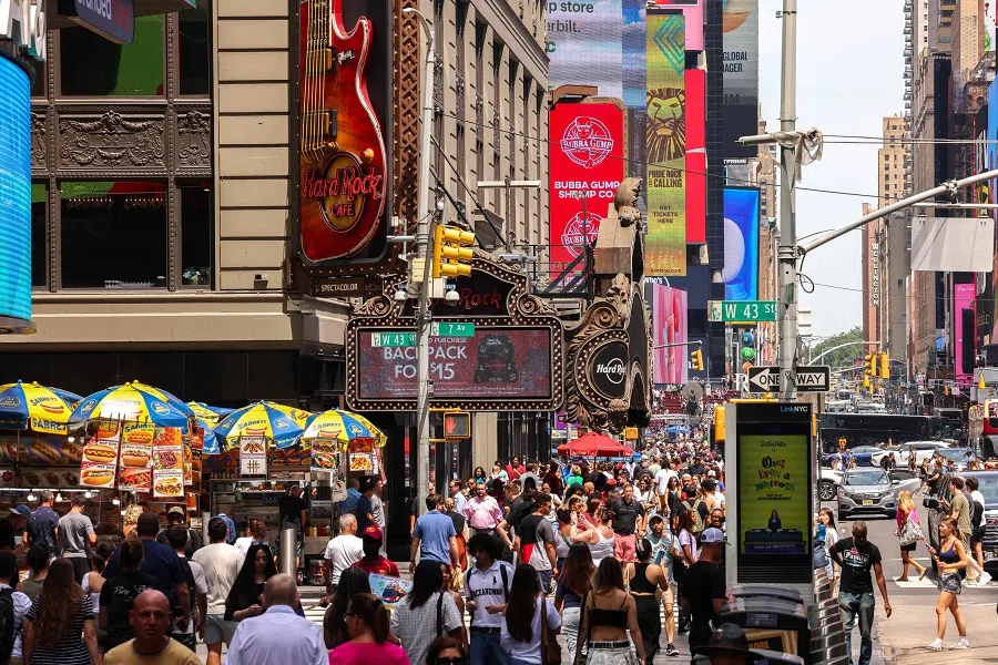 Pedestrians are seen walking in the Times Square area in the Manhattan borough of New York on 23 June 2024. (Charly Triballeau/AFP)